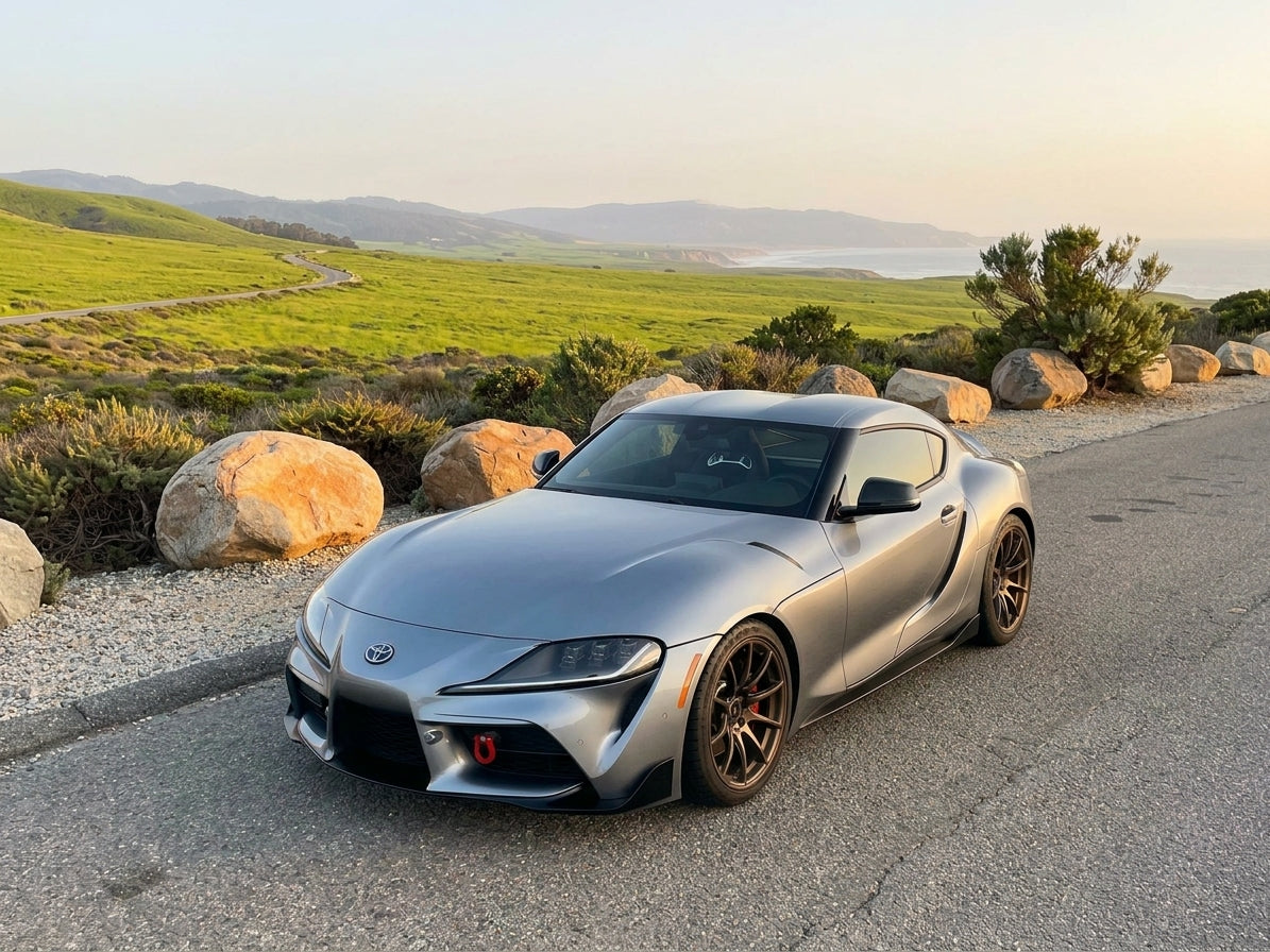 Silver Toyota GR Supra (B58) with bronze wheels on a coastal road – Speed Logic B58 & S58 build packages